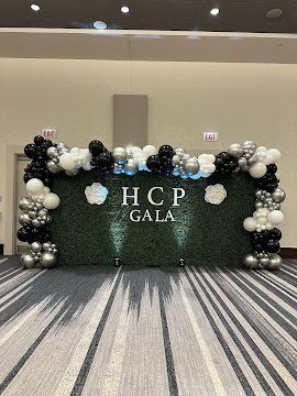 Boxwood hedge wall rental Chicago corporate gala black and silver balloon arch backdrop