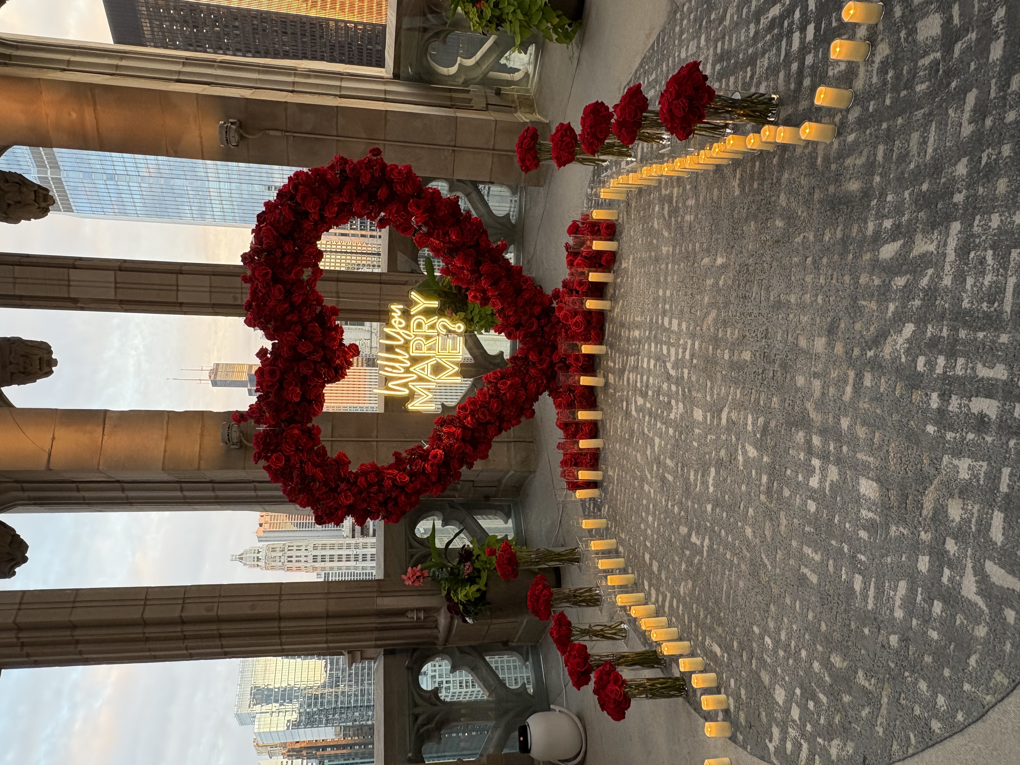 Chicago luxury proposals — Will You Marry Me LED neon sign with red rose arrangements and candlelight ambiance