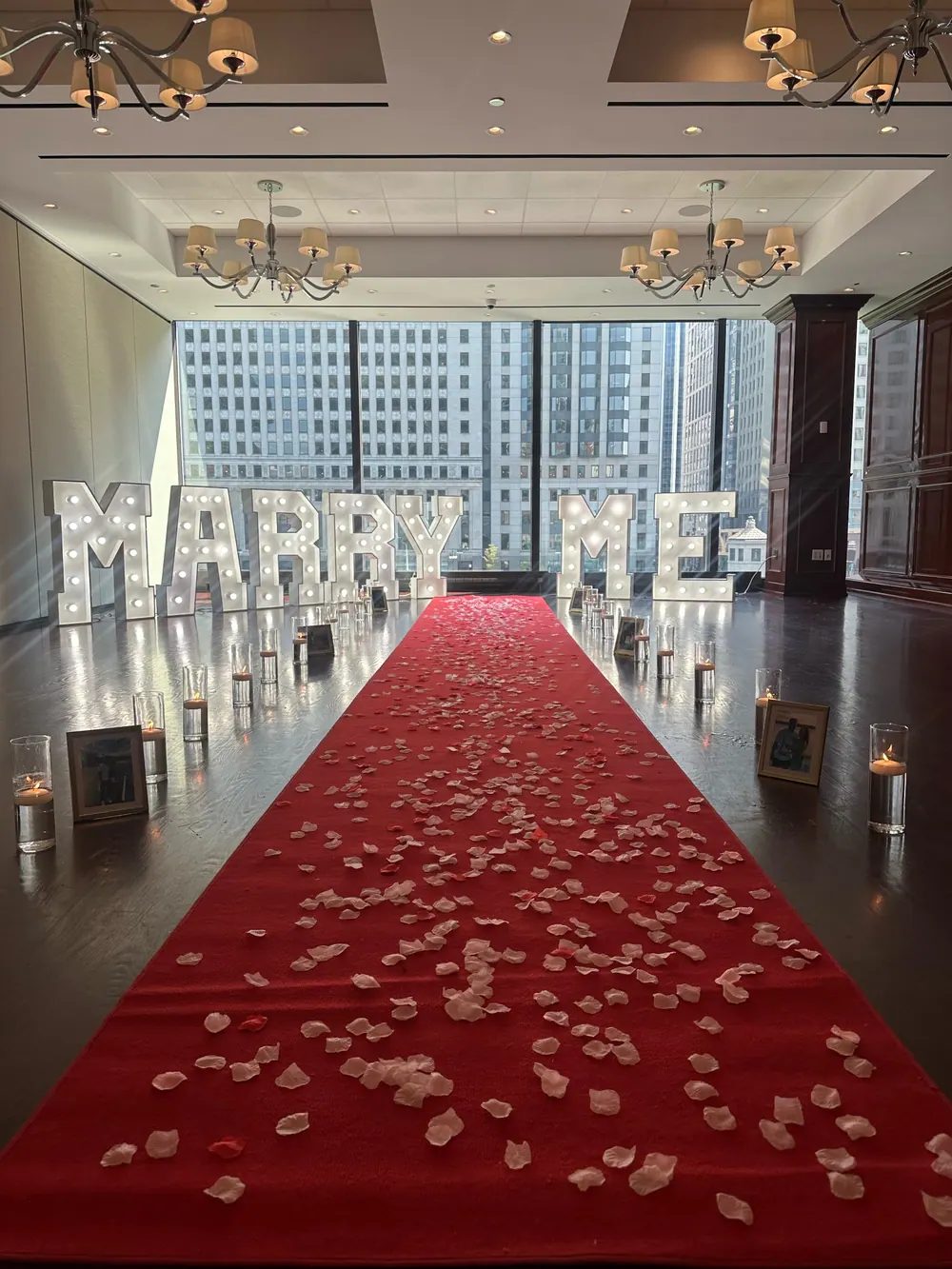 Proposal packages Chicago — romantic proposal setup with flower arch, marquee letters, candles and rose petals