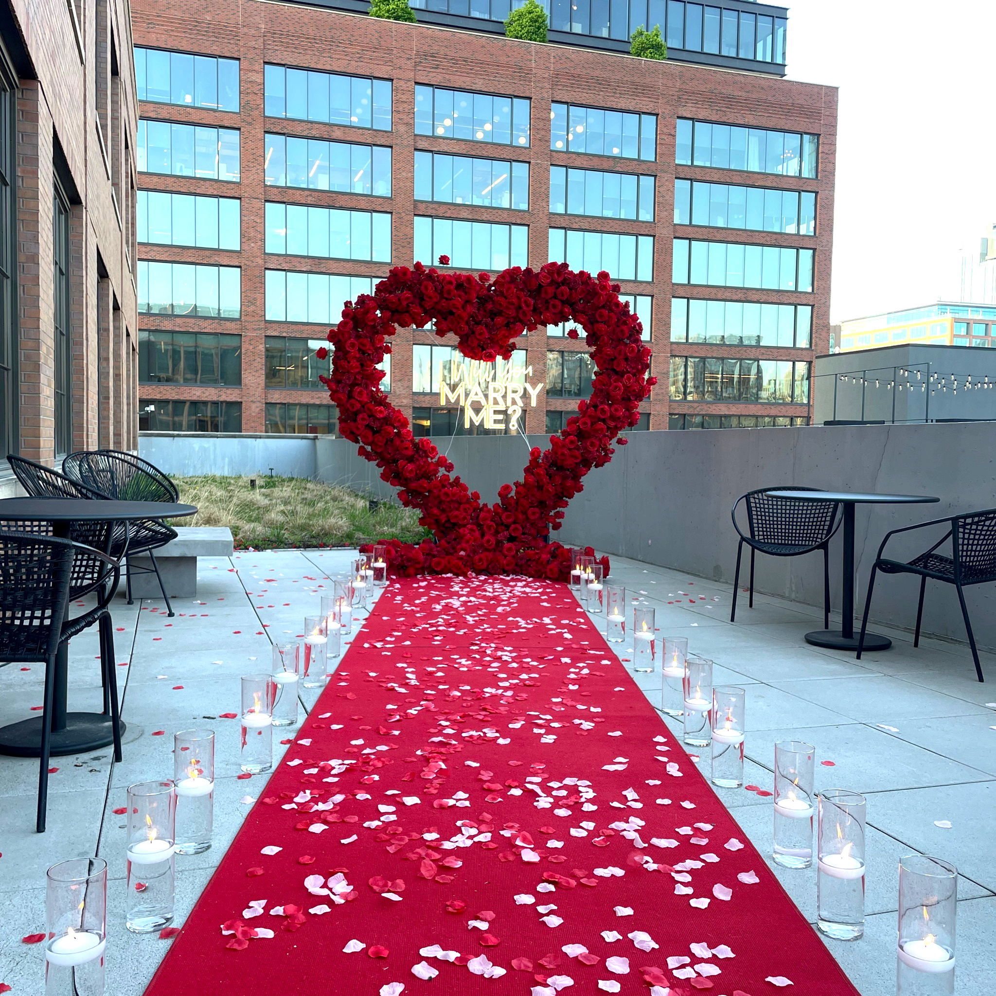 Luxury proposal packages Chicago — romantic heart arch proposal setup with red carpet and rose petals