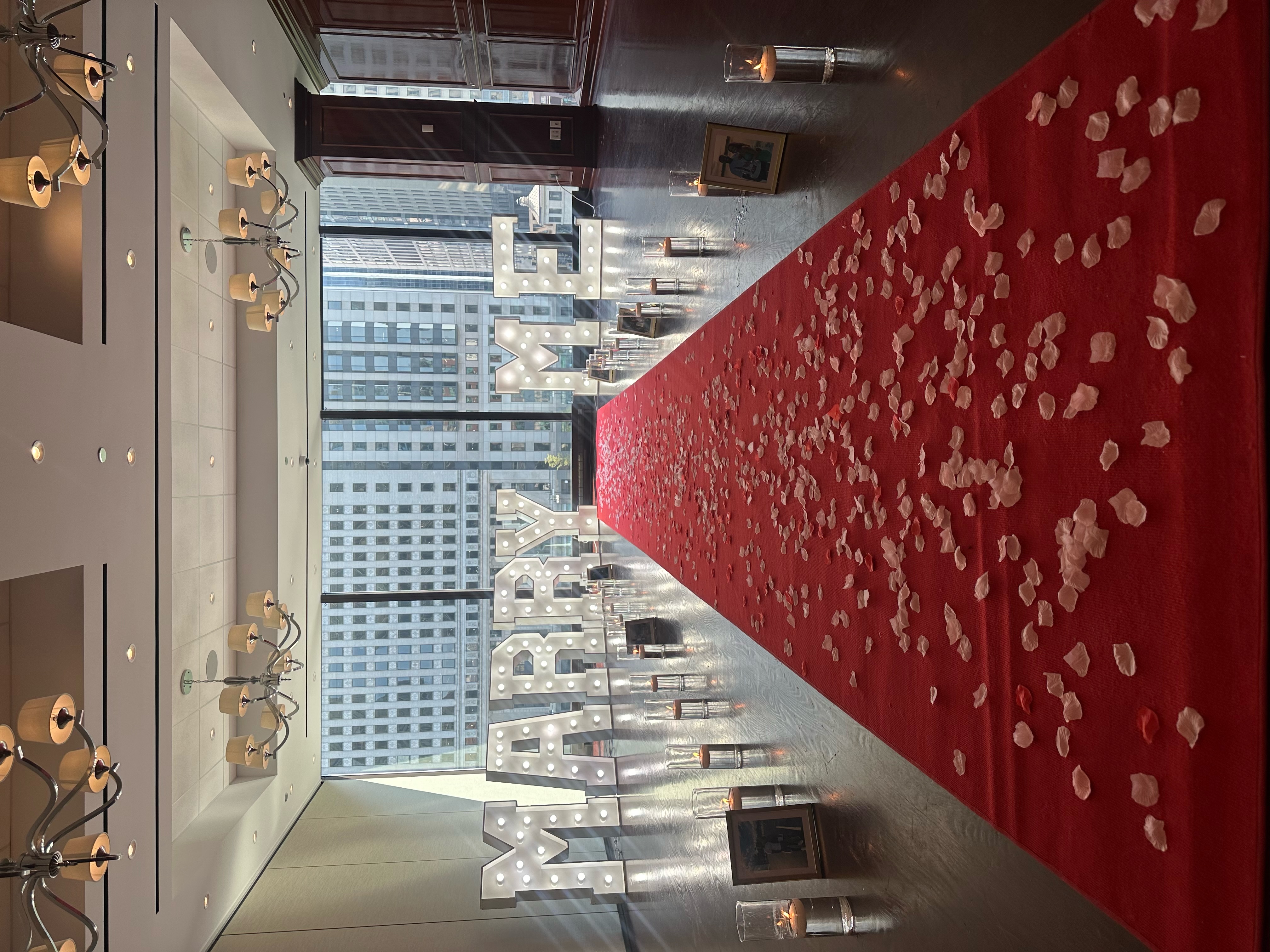 Proposal packages Chicago — romantic proposal setup with flower arch, marquee letters, candles and rose petals