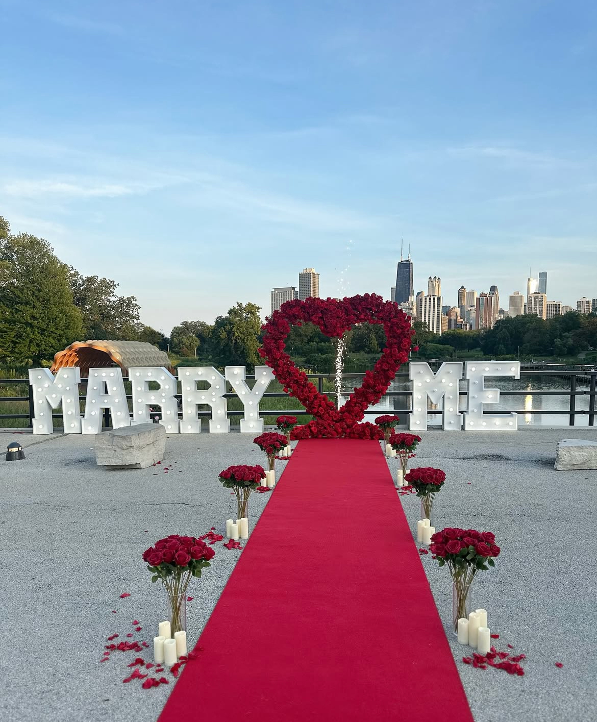 Proposal packages Chicago — intimate proposal setup with floral heart arch, candles, and rose petals
