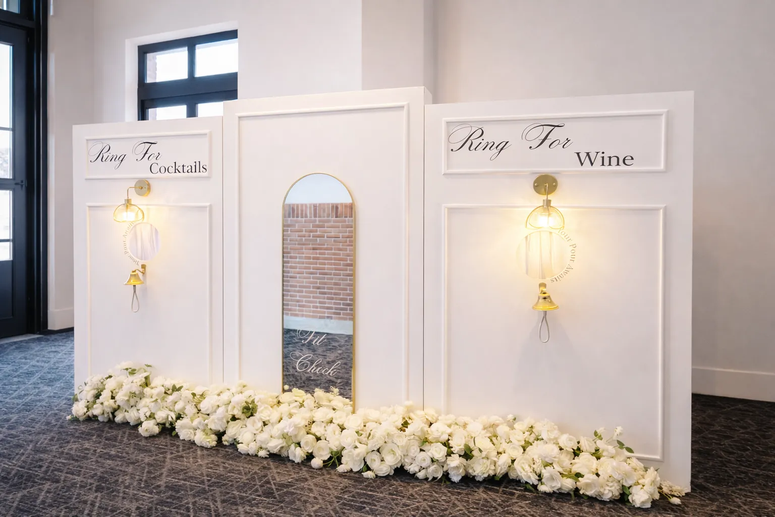 Ring for champagne wall rental Chicago — white tri-panel wall with bells and white floral base