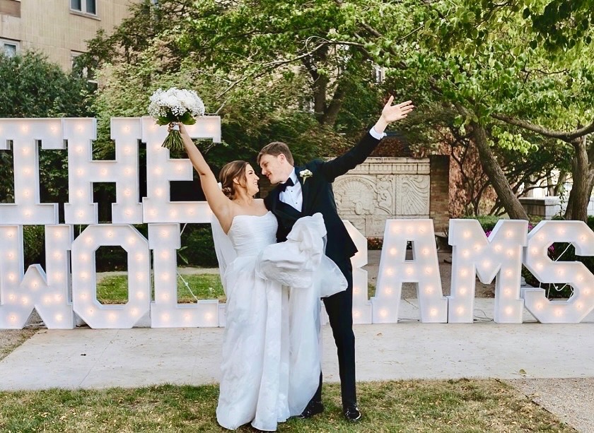 Bride and groom celebrating in front of outdoor marquee letters near Schaumburg