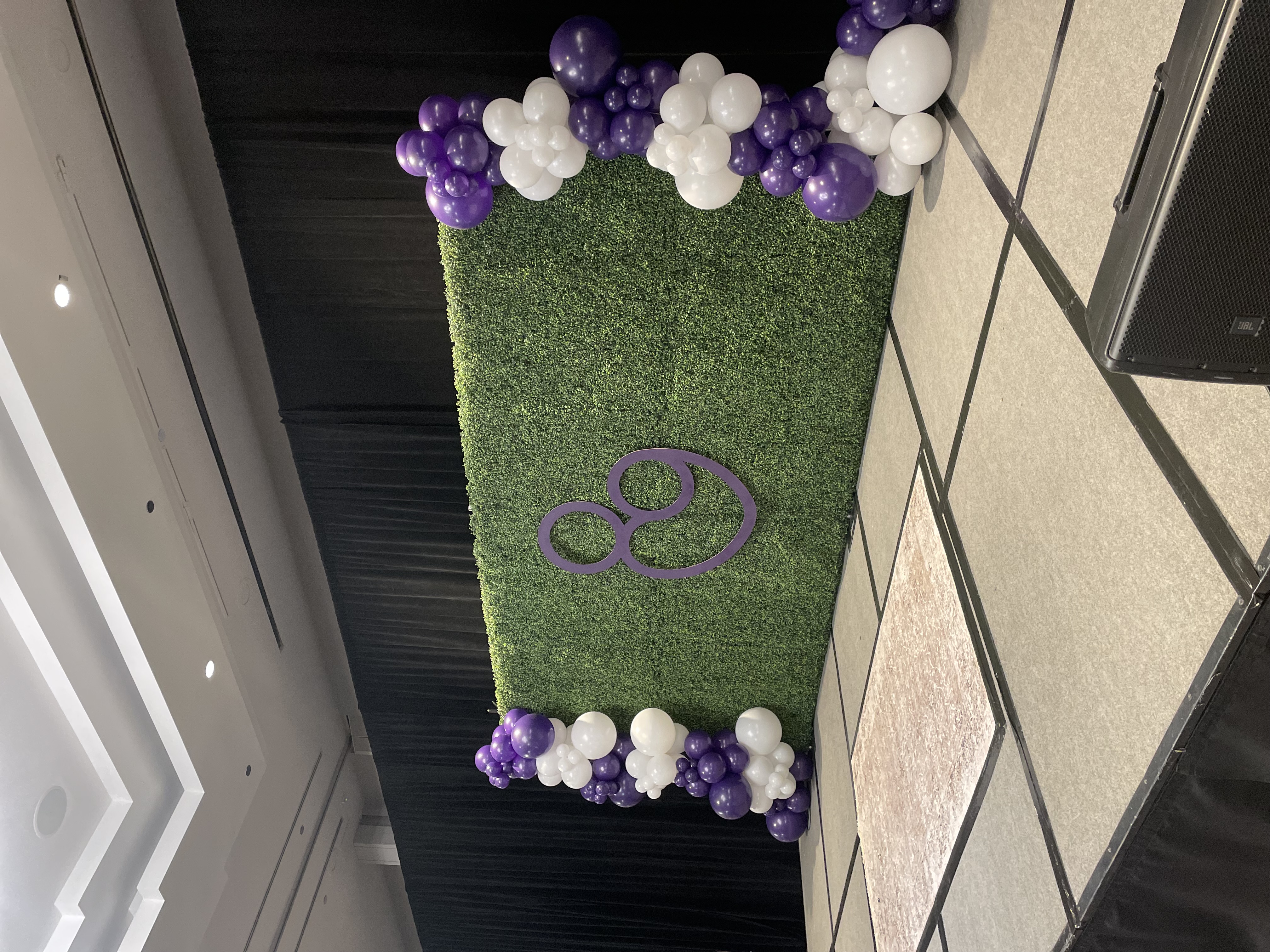 8x16 boxwood greenery wall rental Chicago ballroom event with purple and white balloon arch decor