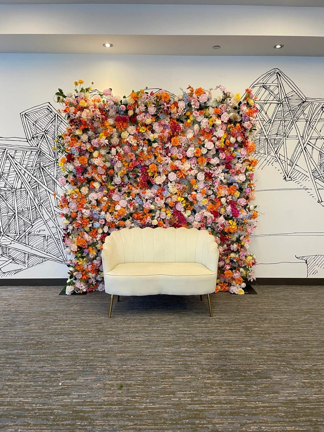 Multicolor flower wall backdrop with white loveseat at a Chicago event