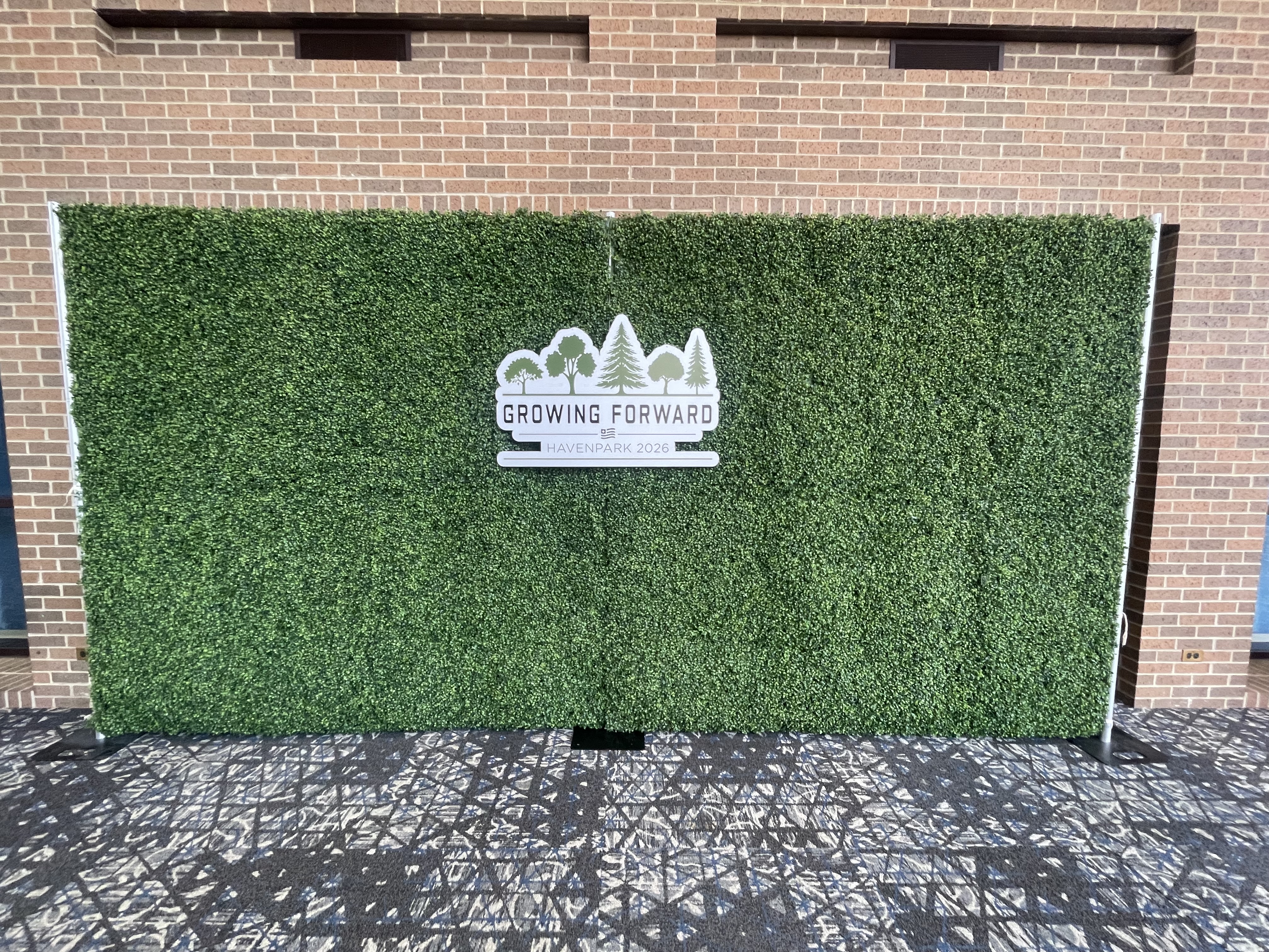 Boxwood hedge wall rental Chicago corporate event — custom branded Growing Forward Havenpark 2026 logo backdrop