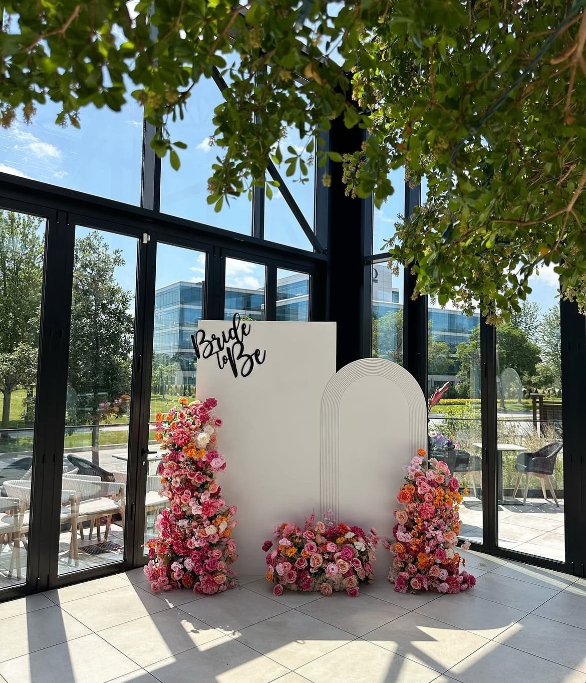 Bridal shower Bride to Be arch backdrop rental Chicago — white panel arch with colorful pink orange floral columns