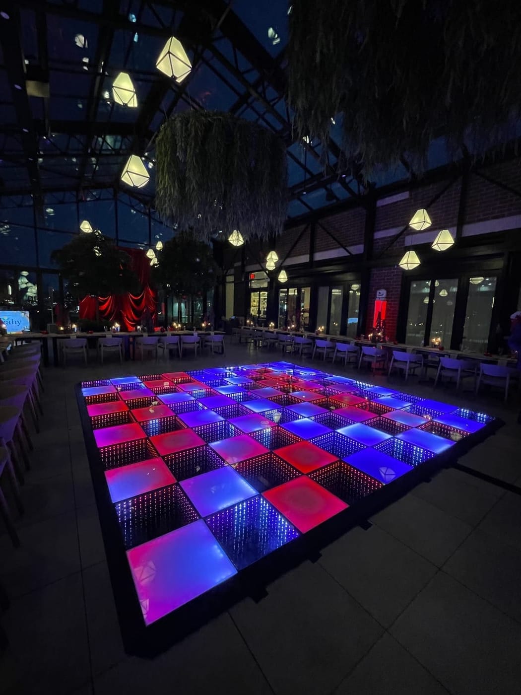 Glow dance floor rental in Chicago with pink and blue infinity panels lighting a darkened event hall