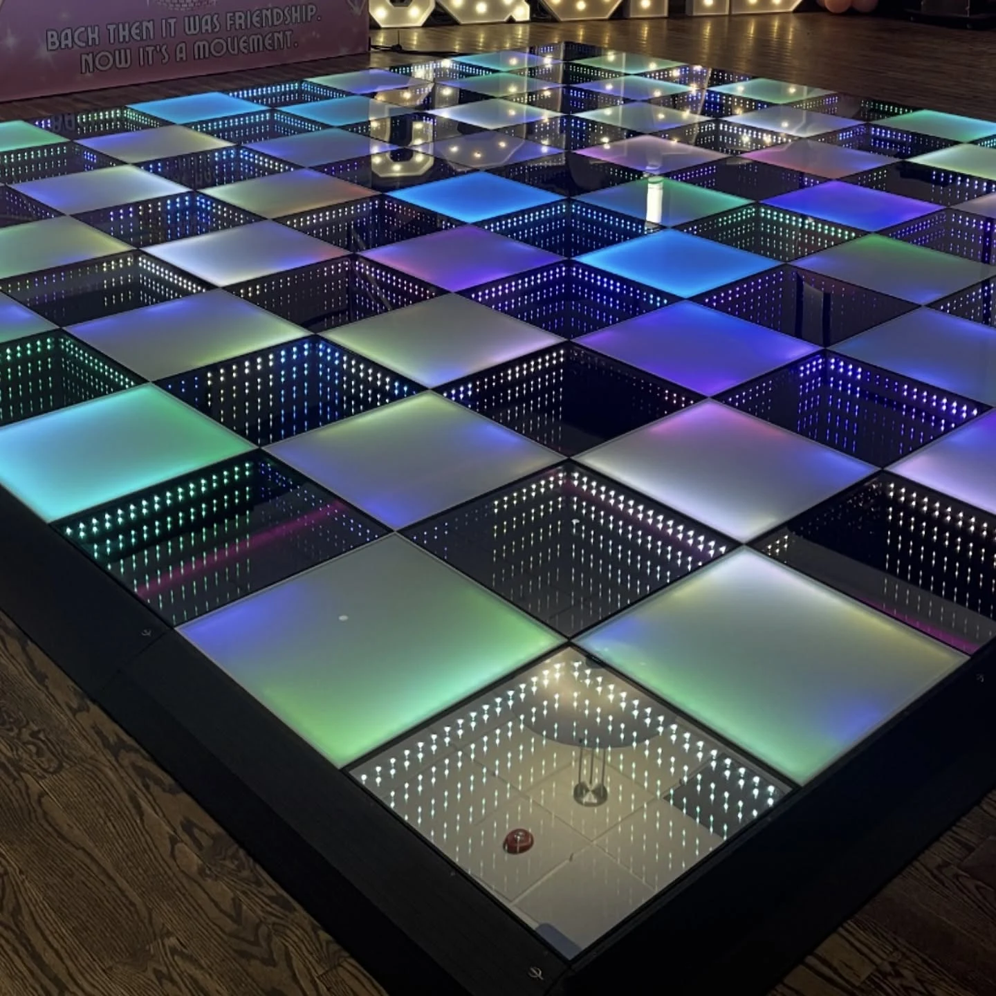 LED dance floor rental in Oak Brook with infinity mirror panels and blue green and purple light up dance floor panels on a wood venue floor