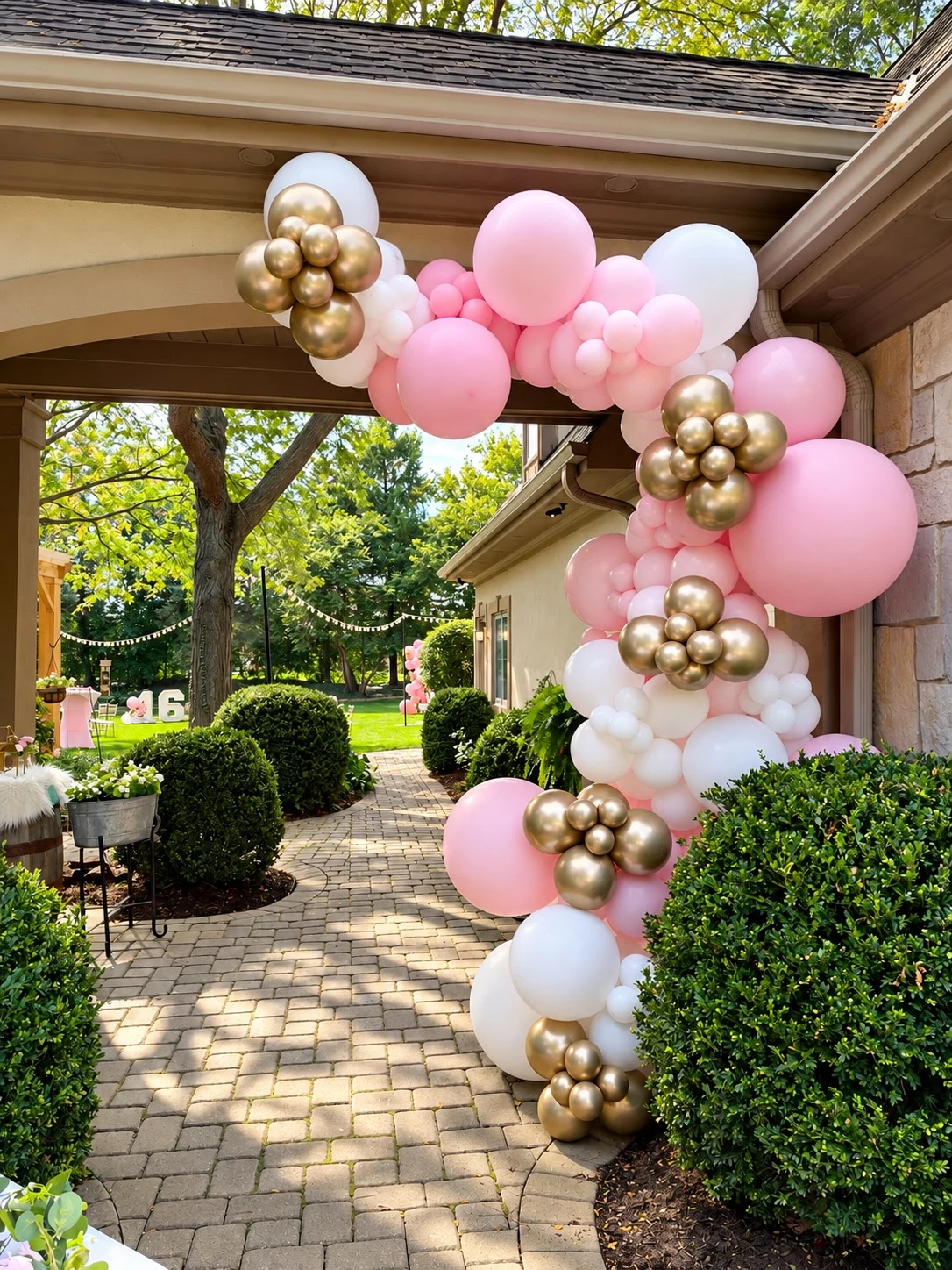 sweet 16 flower wall rental in Chicago — pink, white and chrome gold balloon garland framing a home entry in St. Charles with white 16 numbers on the lawn
