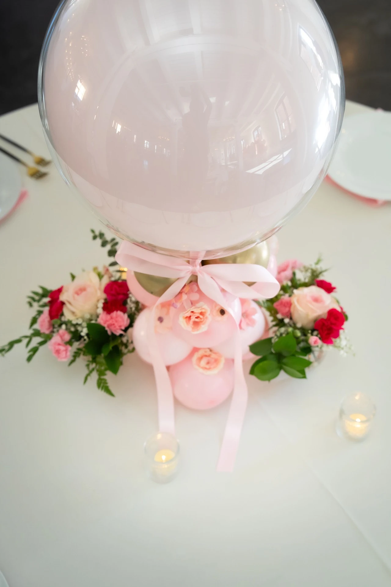balloon centerpiece rental in Chicago — pale pink orb balloon centerpiece with bow and floral accents on a guest table