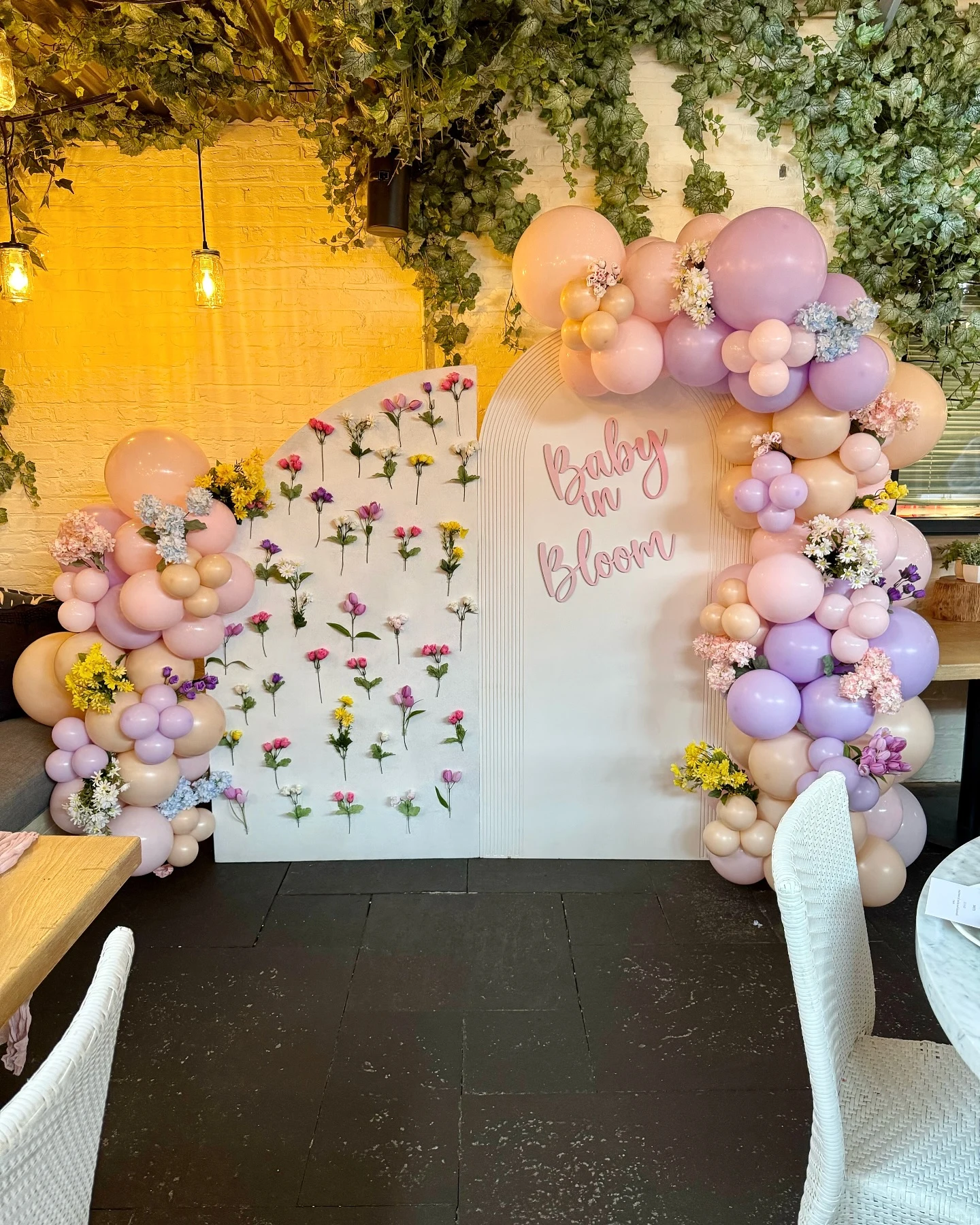 baby shower backdrop rental in Chicago — white arch panel with pink 'Baby in Bloom' lettering, pink and lavender balloon garlands and a fresh flower panel at Summer House in Lincoln Park