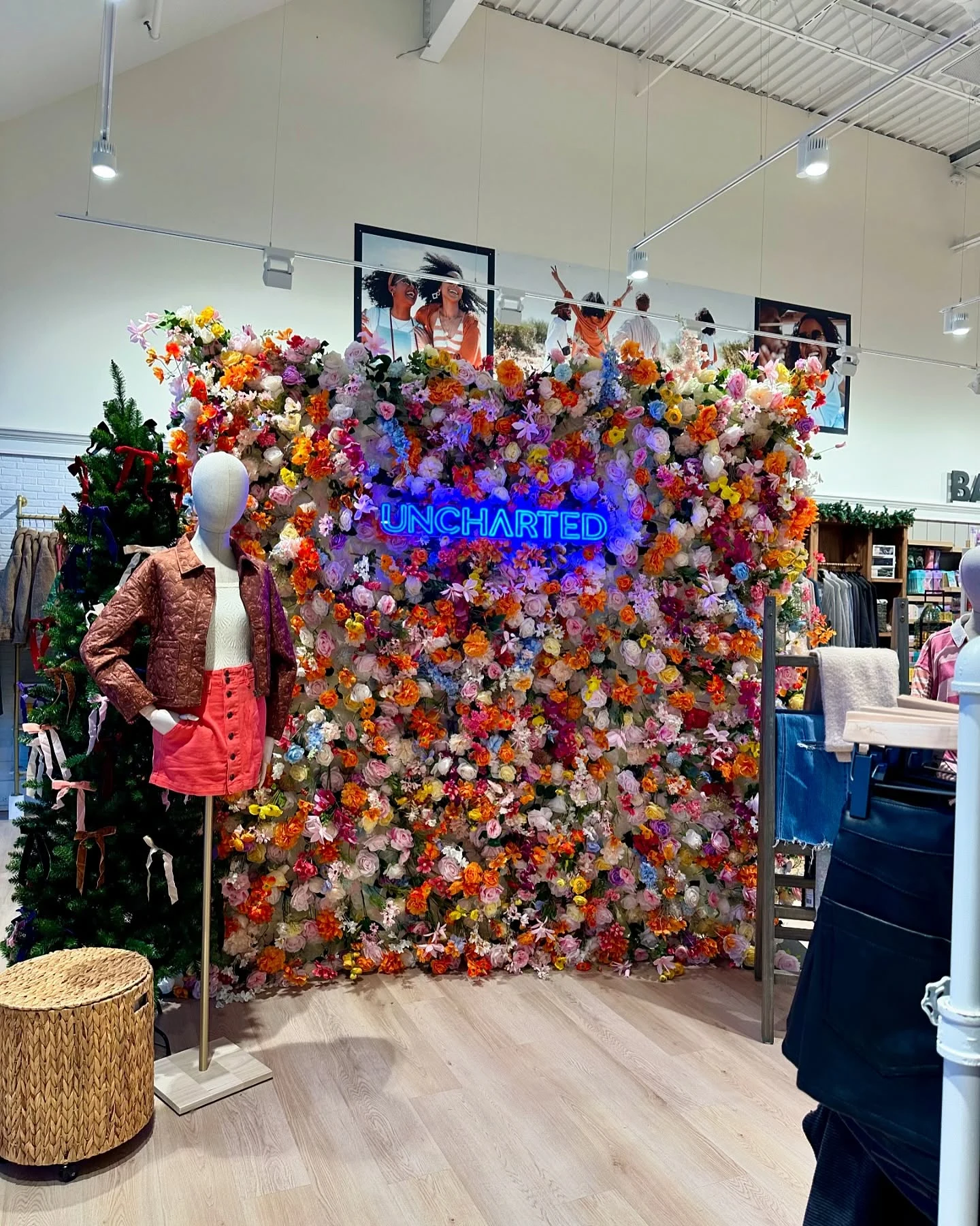 flower wall rental in Oak Brook — multicolor flower wall with a blue neon Uncharted sign on display inside the Uncharted store