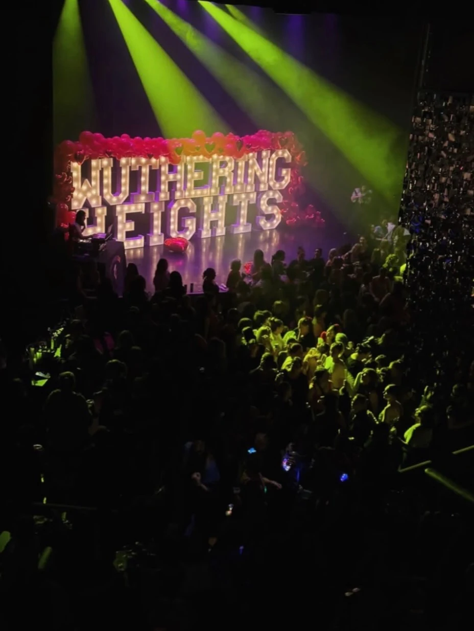 Marquee letters in Chicago glowing above a packed launch party crowd at Park West under green spotlight beams