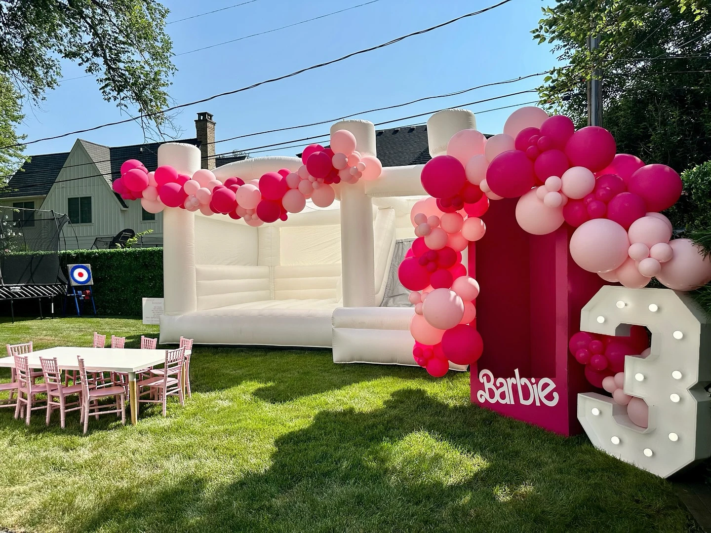 Barbie box backdrop rental in Elmhurst — a tall magenta Barbie photo box with white script lettering, a light-up marquee number 3, and hot pink and blush balloon garlands at a third birthday